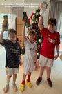 Three boys carrying an H2Q bottle each and raising their hands up in the air.